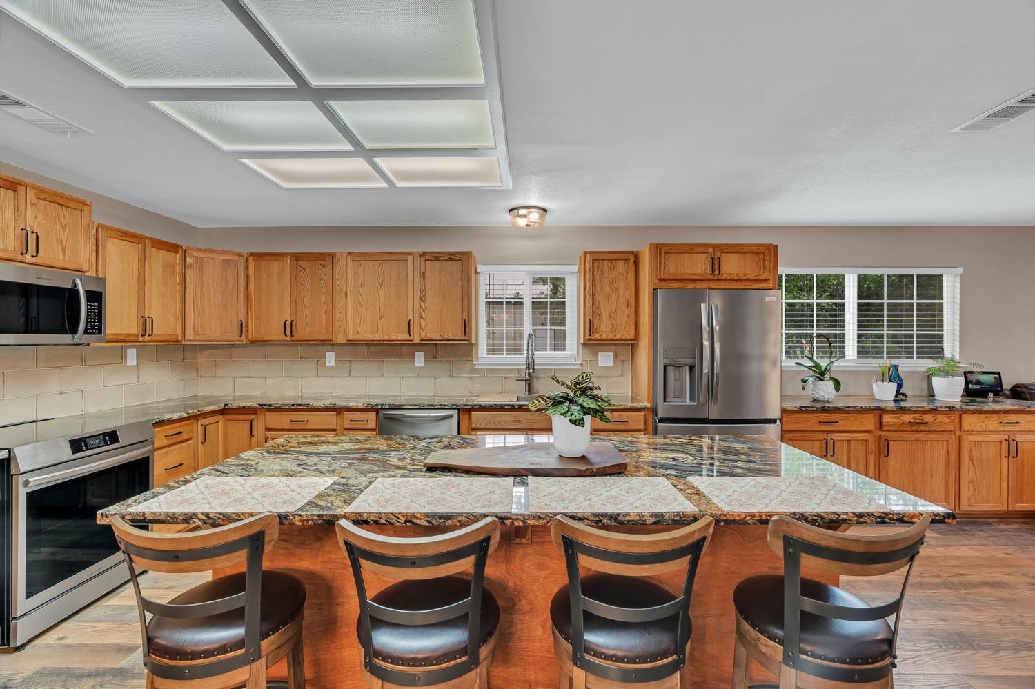 12354 Hobday Road Wilton, CA 95693 - Photo 41 of 77 kitchen with light wood finished floors, stainless steel appliances, a kitchen island, a breakfast bar area, and wood finish cabinets