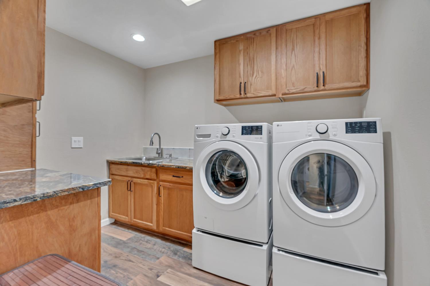 12354 Hobday Road Wilton, CA 95693 - Photo 49 of 77 laundry room featuring light wood-style flooring, cabinet space, washer and clothes dryer, and recessed lighting