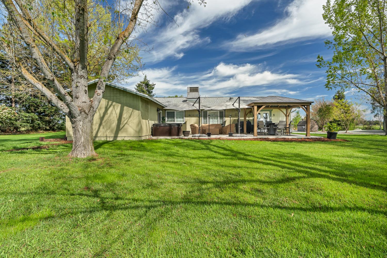 12354 Hobday Road Wilton, CA 95693 - Photo 5 of 77 back of house with a gazebo, a hot tub, a patio, and a yard