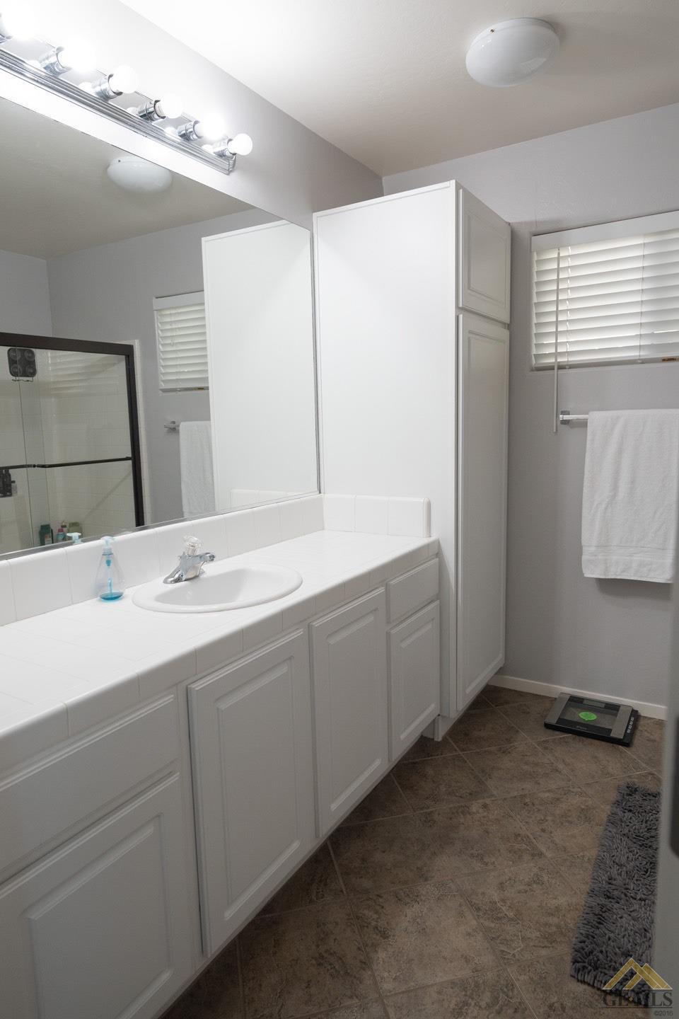 Undisclosed Address Bakersfield, CA 93312 - Photo 13 of 21 a bathroom with a double vanity sink and mirror