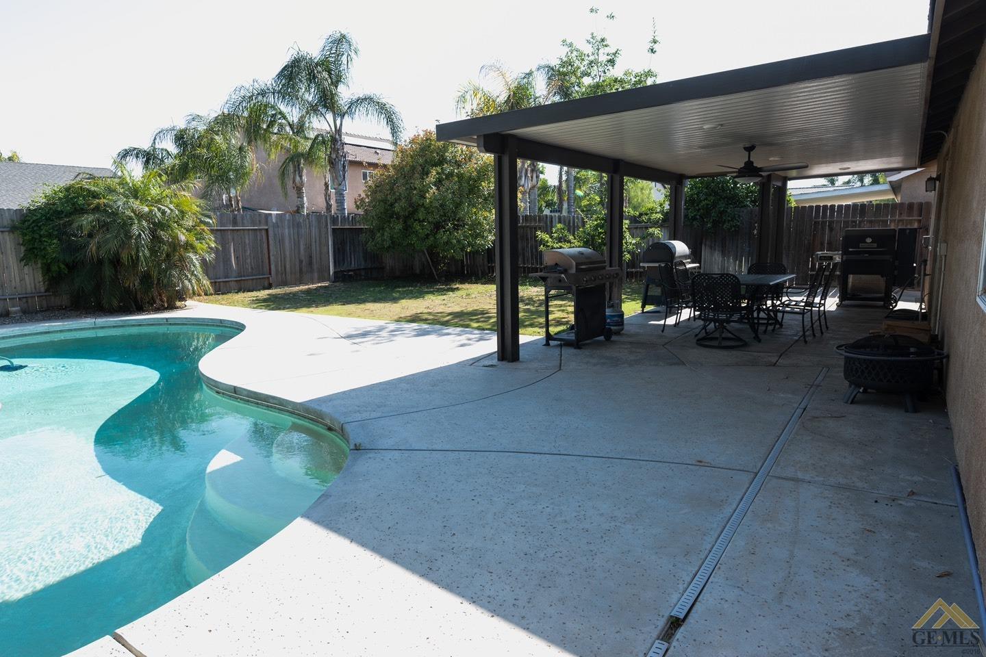Undisclosed Address Bakersfield, CA 93312 - Photo 19 of 21 a view of a patio with table and chairs under an umbrella