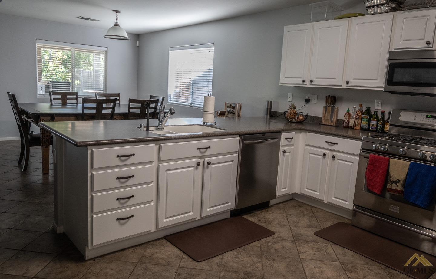 Undisclosed Address Bakersfield, CA 93312 - Photo 4 of 21 a kitchen with granite countertop a sink white cabinets and stainless steel appliances