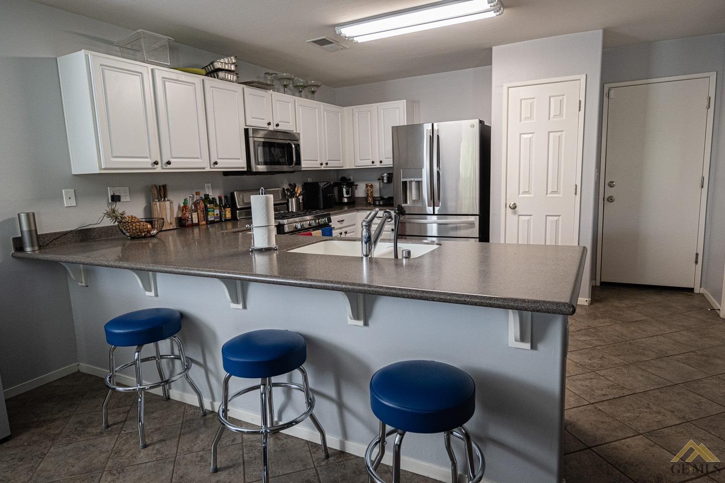 Undisclosed Address Bakersfield, CA 93312 - Photo 6 of 21 a kitchen with stainless steel appliances granite countertop a sink a stove a refrigerator cabinets and dining table
