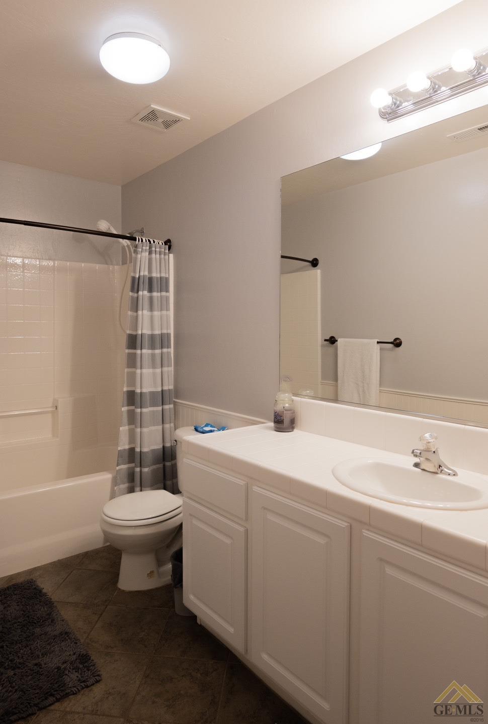 Undisclosed Address Bakersfield, CA 93312 - Photo 9 of 21 a bathroom with a sink toilet a mirror and shower