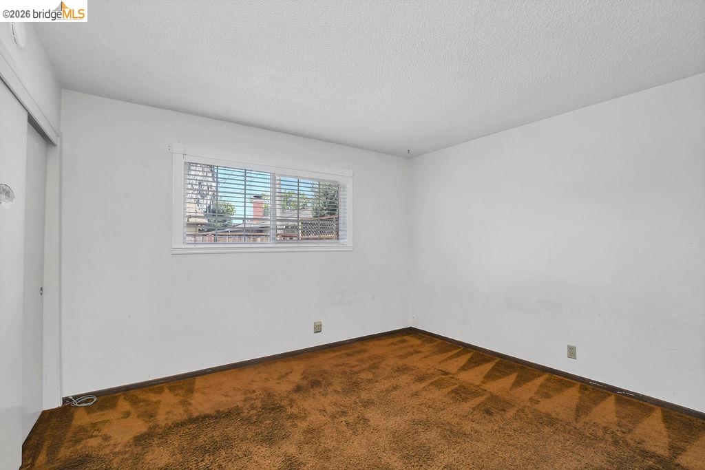 805 Calero Street Milpitas, CA 95035 - Photo 15 of 23 Interior room featuring a white ceiling and walls with brown patterned carpeting