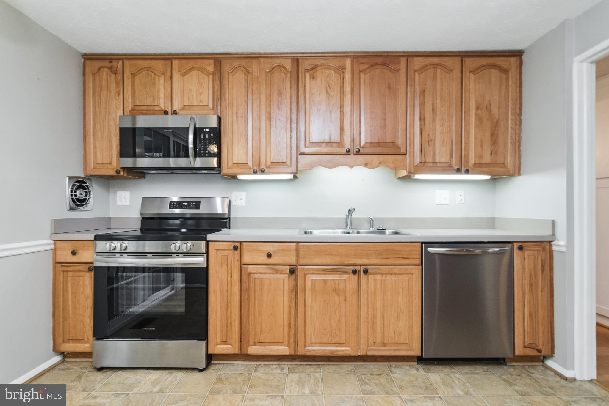 2806 Logway Road Vienna, VA 22181 - Photo 9 of 42 a kitchen with wooden cabinets and a stove top oven