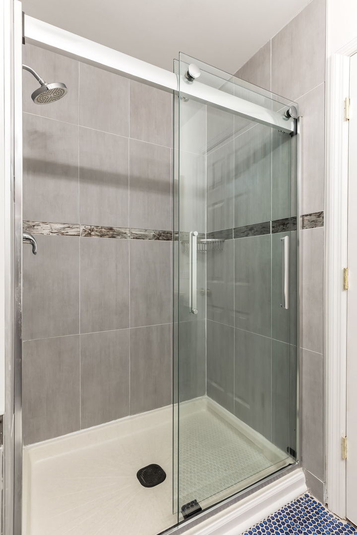 1251 West Fletcher Street, Unit J Chicago, IL 60657 - Photo 23 of 30 a bathroom with a glass shower door
