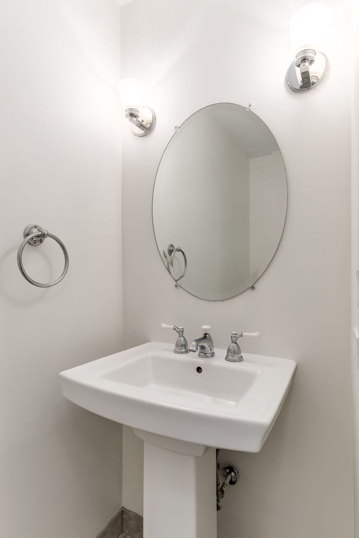 1251 West Fletcher Street, Unit J Chicago, IL 60657 - Photo 24 of 30 a bathroom with a sink and mirror