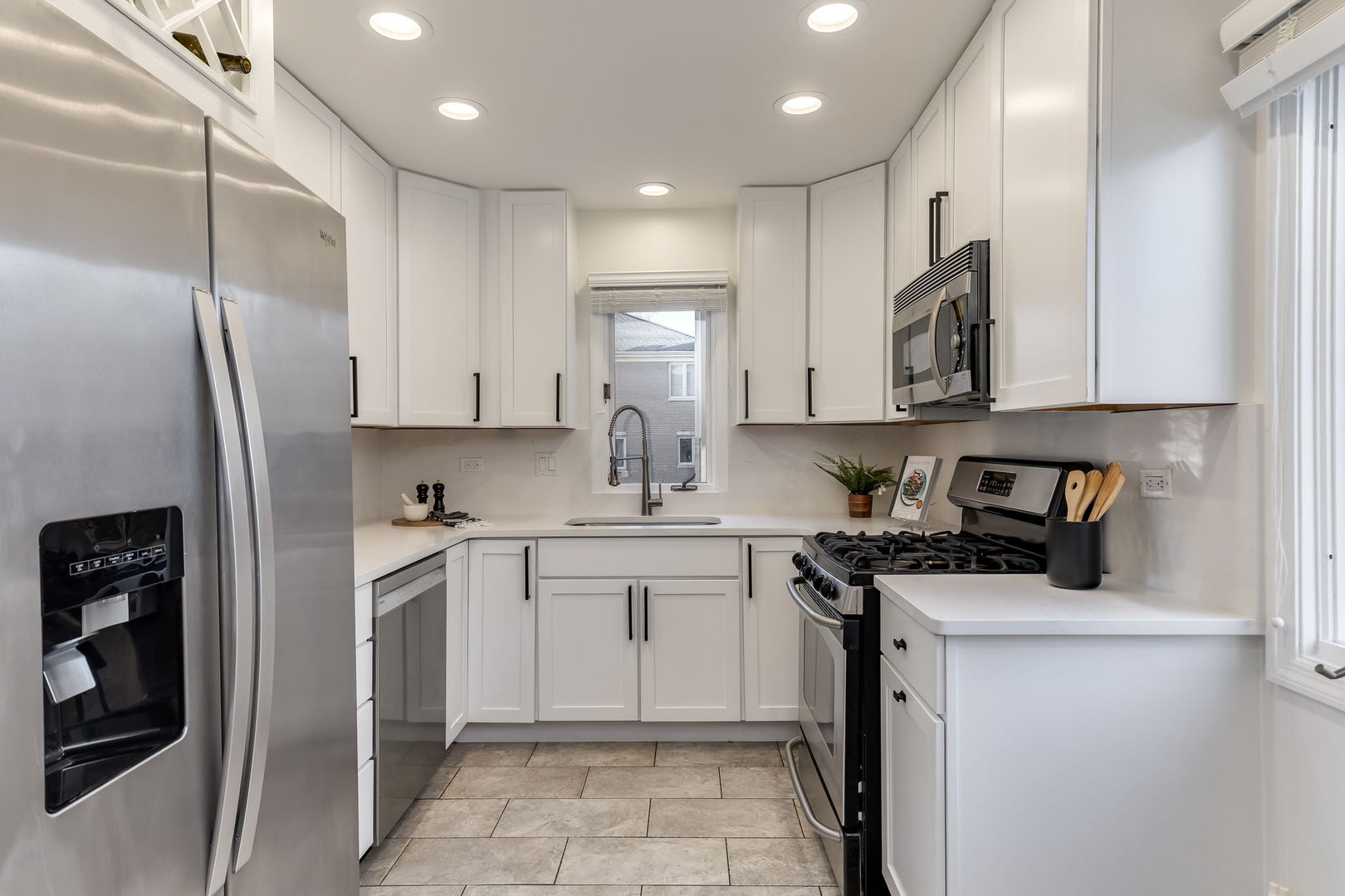 1251 West Fletcher Street, Unit J Chicago, IL 60657 - Photo 9 of 30 a kitchen with stainless steel appliances granite countertop a refrigerator sink and cabinets
