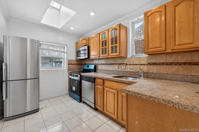 a kitchen with stainless steel appliances granite countertop a refrigerator and a stove top oven