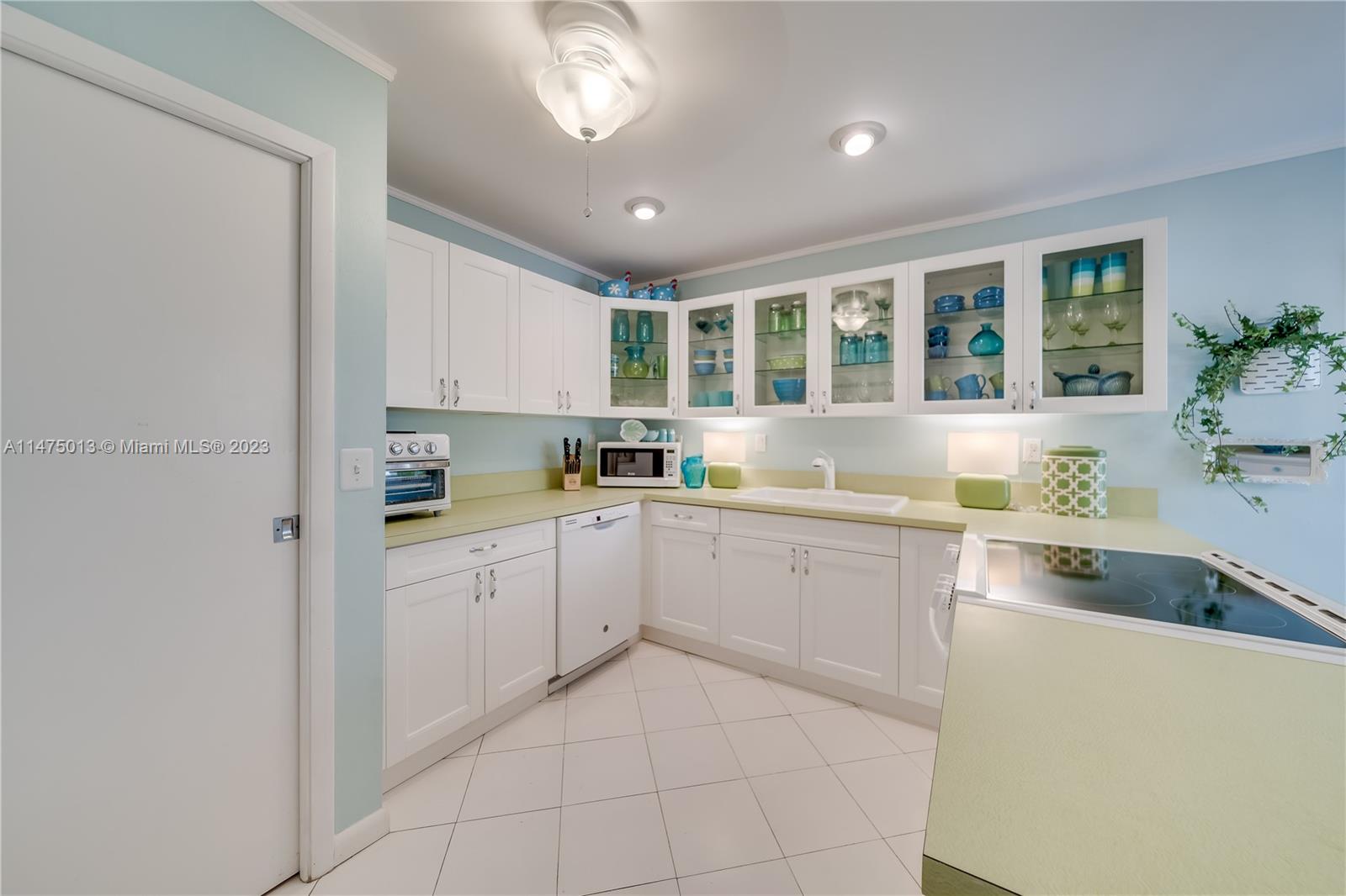 950 Mockingbird Lane, Unit 609A Plantation, FL 33324 - Photo 40 of 64 a kitchen with a refrigerator and white cabinets