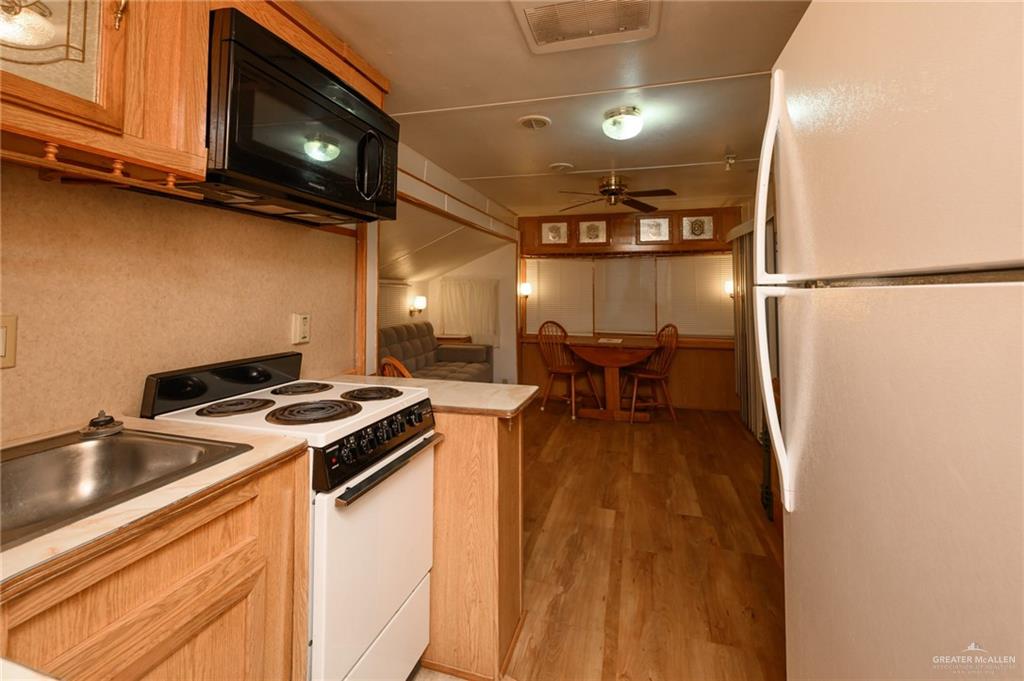 215 South Valley View Road, Unit 227 Donna, TX 78537 - Photo 8 of 18 a kitchen with a stove and a microwave