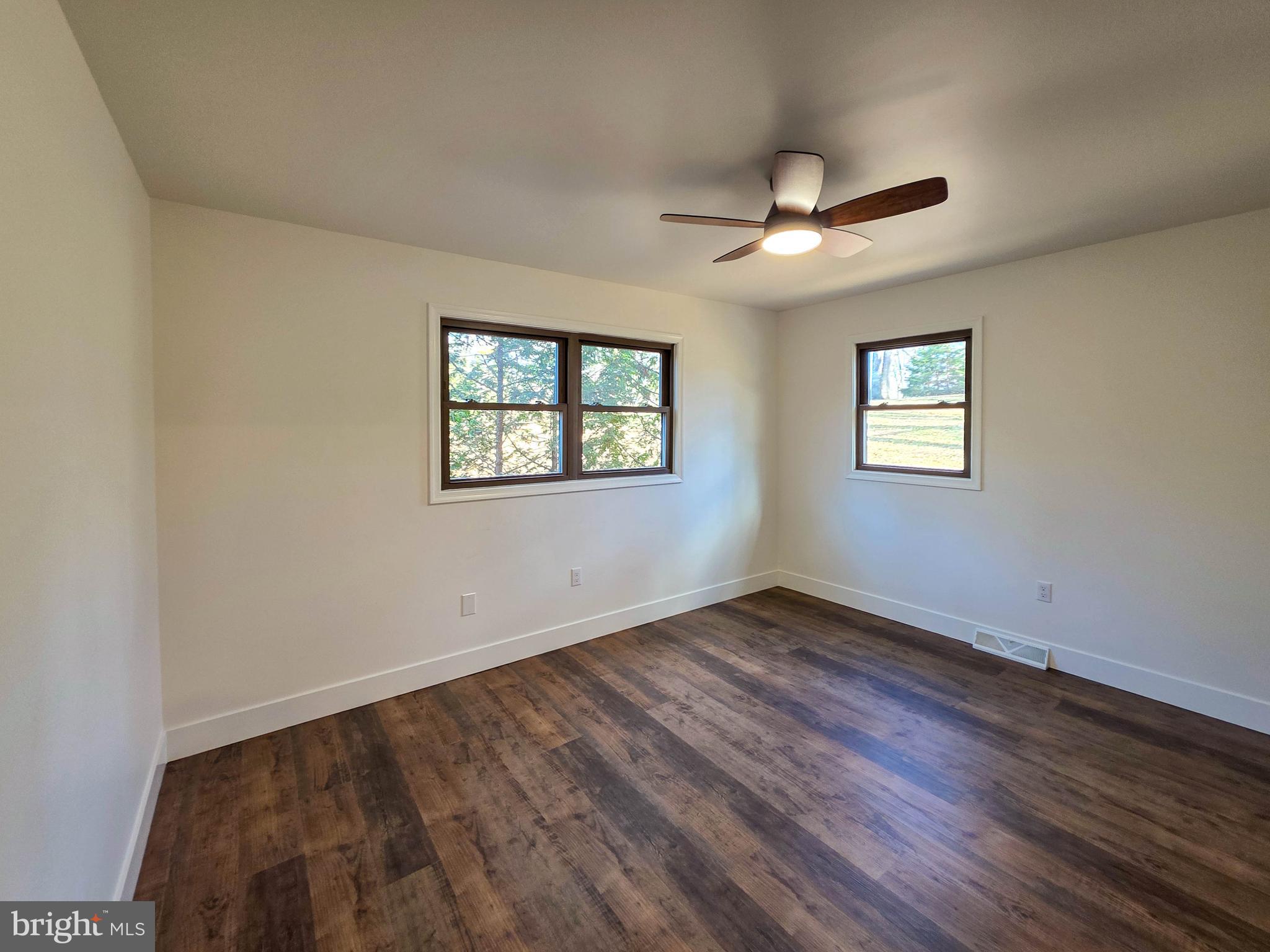 1700 McDowell Road Greencastle, PA 17225 - Photo 9 of 40 an empty room with wooden floor ceiling fan and windows