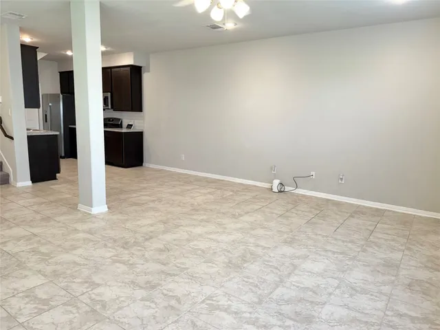 a view of an empty room with a kitchen