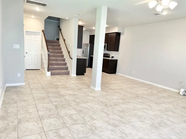 a view of a kitchen with stainless steel appliances wooden floor and living room