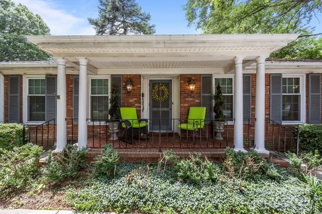 front view of house with a large window and potted plants