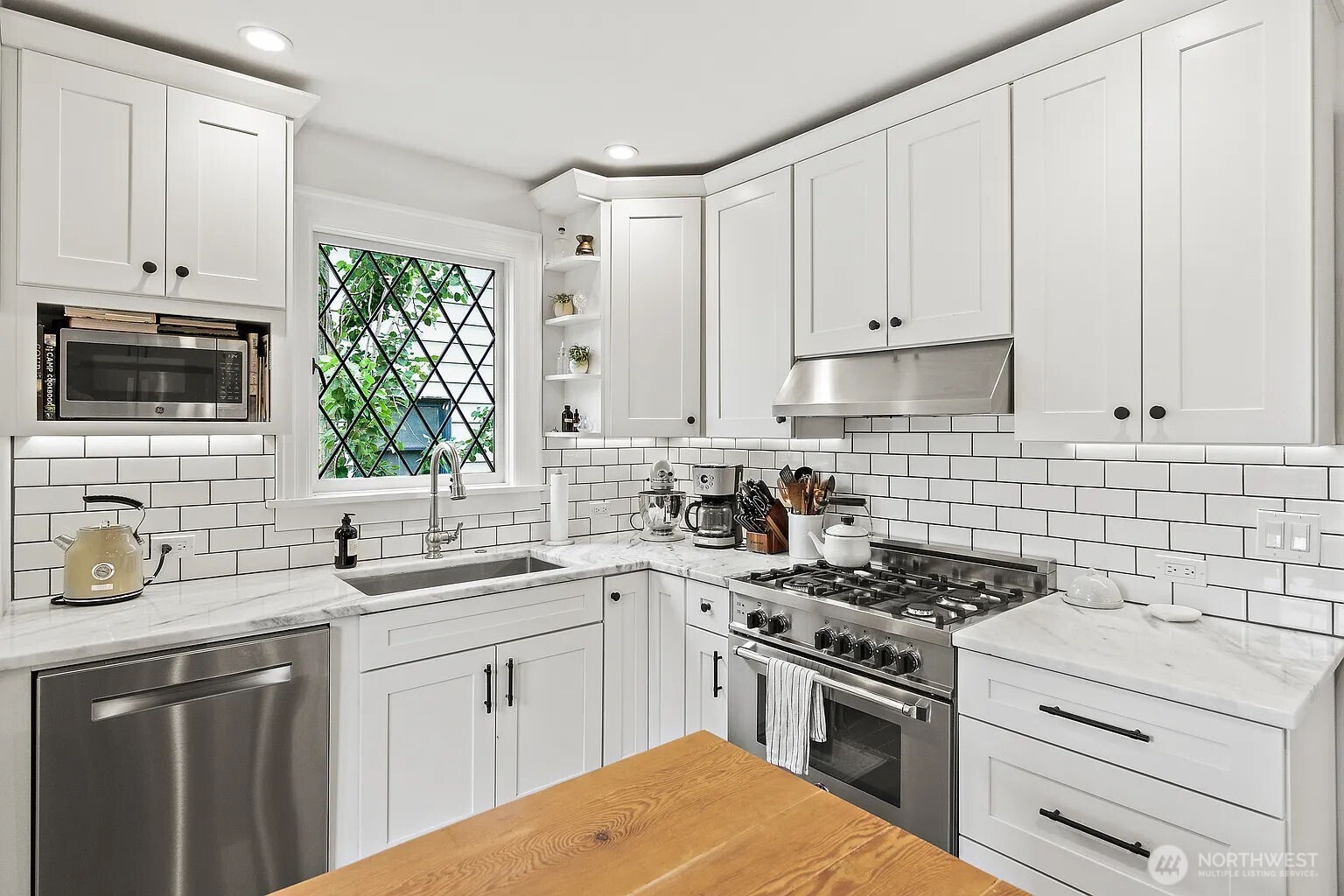 1114 North 77th Street Seattle, WA 98103 - Photo 6 of 30 a kitchen with cabinets stainless steel appliances a sink and a window
