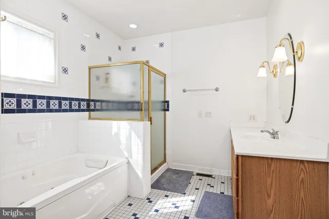 a bathroom with a tub a sink and a mirror