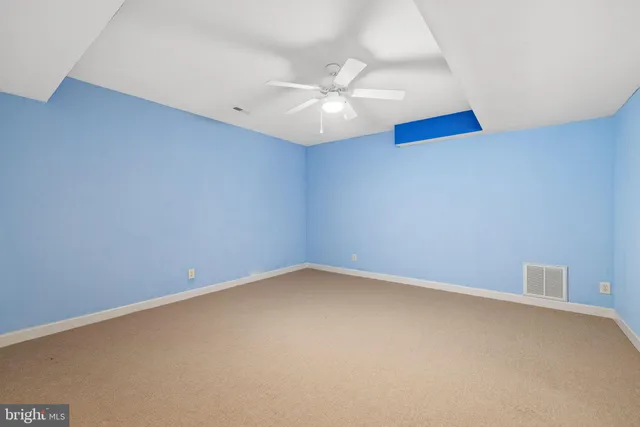 an empty room with a window and a ceiling fan