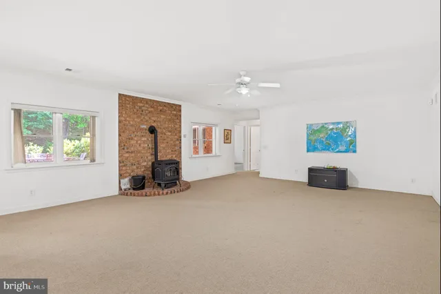 an empty room with windows and fireplace