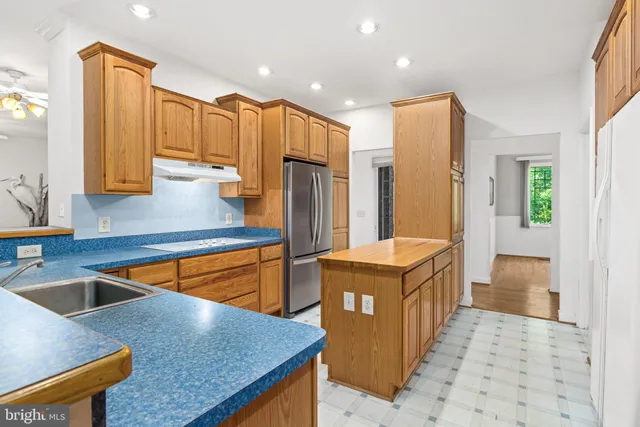 a kitchen with stainless steel appliances granite countertop a sink a stove and refrigerator