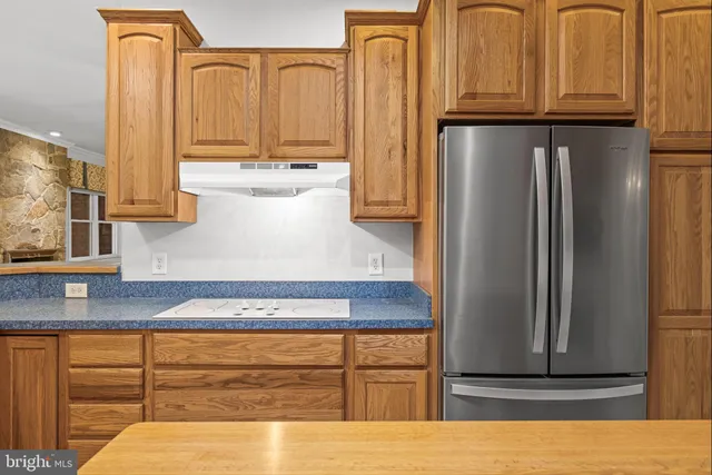 a kitchen with stainless steel appliances granite countertop a refrigerator and cabinets