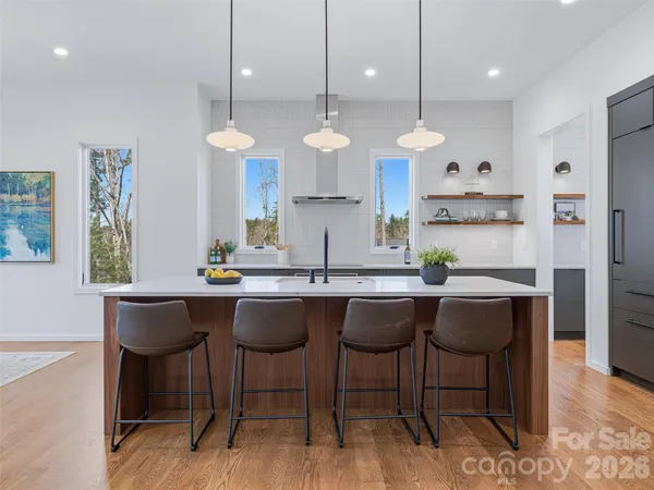 a kitchen with a dining table chairs sink and wooden floor