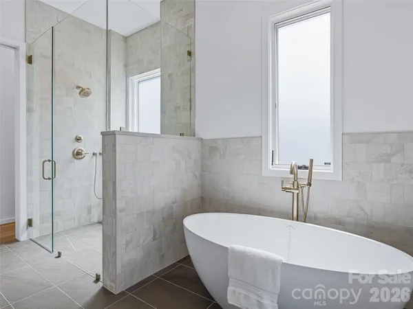 a white bath tub sitting next to a shower