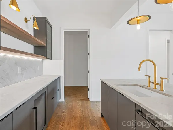 a kitchen with a sink cabinets and wooden floor