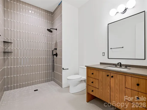 a bathroom with a double vanity sink toilet mirror and shower