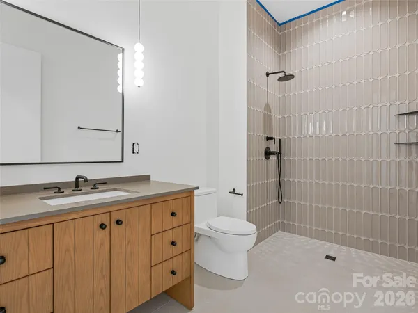 a bathroom with a granite countertop sink a toilet and shower