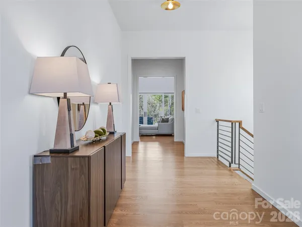 a view of a hallway with wooden floor and stairs