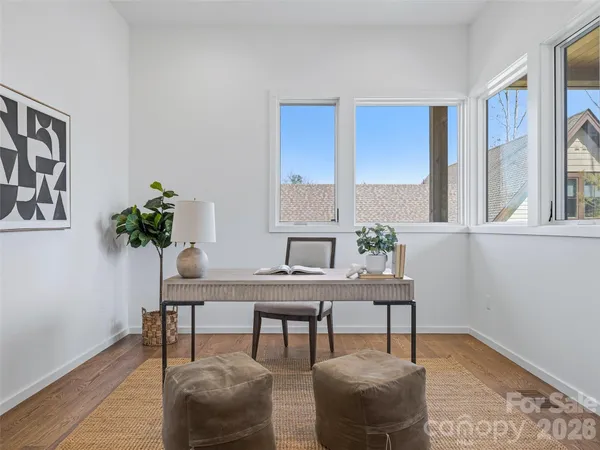 a view of a workspace room with furniture and wooden floor
