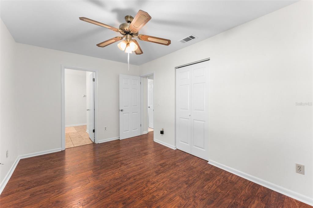 2026 Southwest 73rd Street Gainesville, FL 32607 - Photo 9 of 20 an empty room with wooden floor and ceiling fan