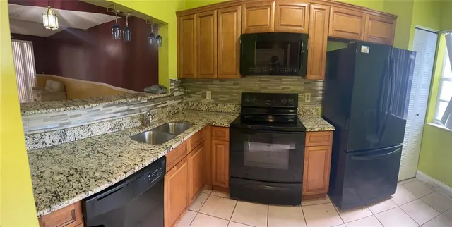 a kitchen with granite countertop a sink and a stove