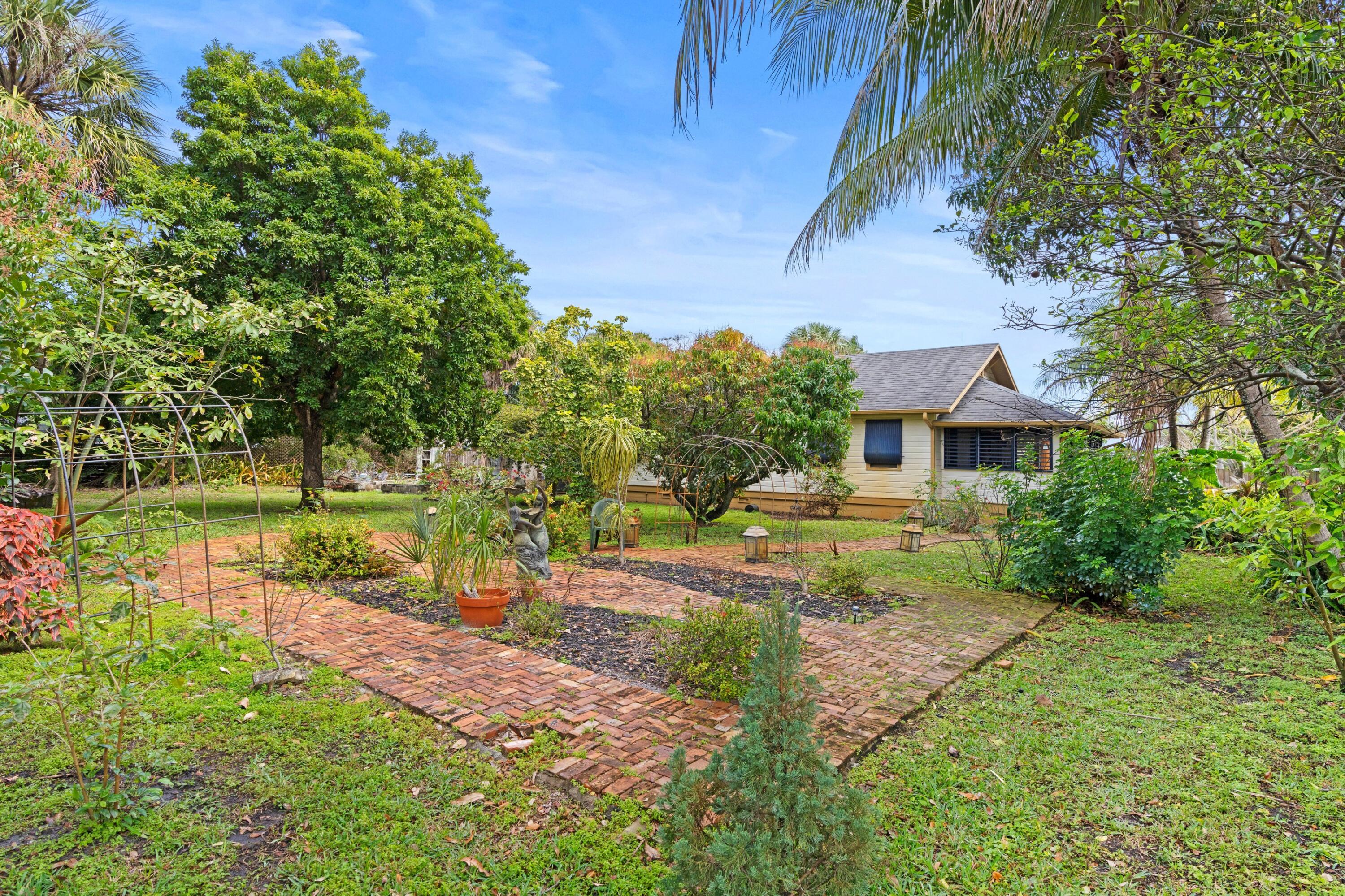 913 Sunset Road West Palm Beach, FL 33401 - Photo 3 of 12 a view of a house with a yard and sitting area
