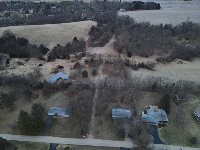 a view of a dry yard with trees in the background