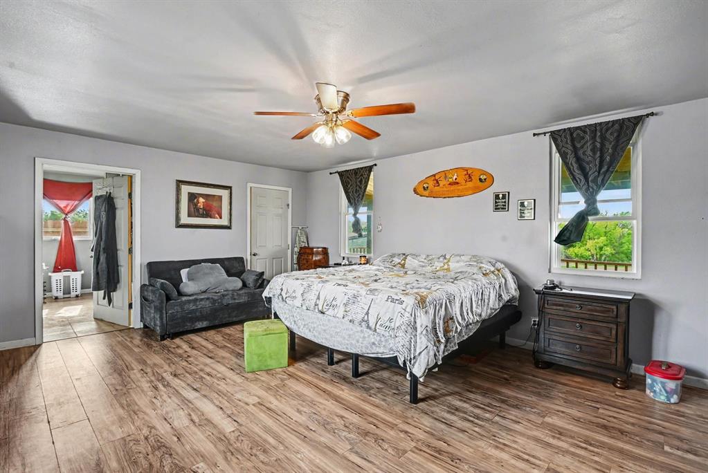 6694 Hutcheson Hill Road Springtown, TX 76082 - Photo 13 of 37 a bedroom with a bed and a chandelier