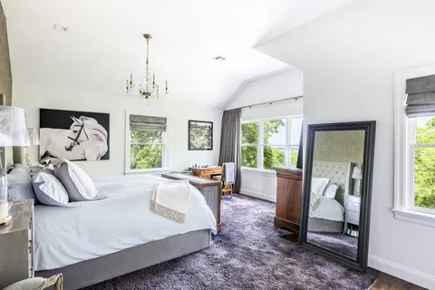 a bedroom with furniture and a large window