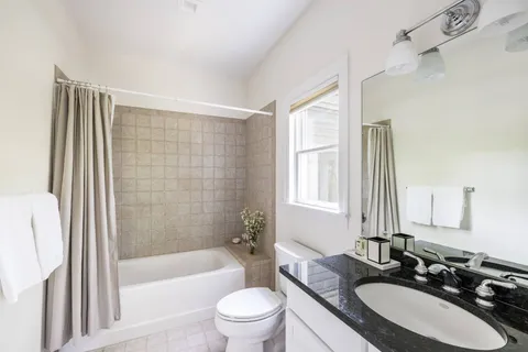 a bathroom with a granite countertop sink toilet and shower