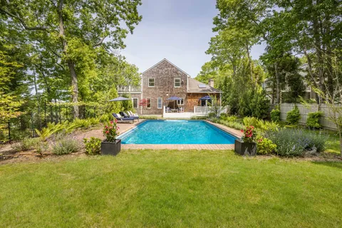 a view of house with yard and outdoor seating