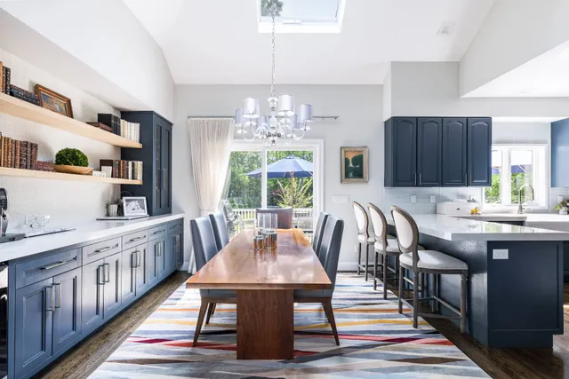 a dining room with wooden floor a chandelier a wooden table and chairs