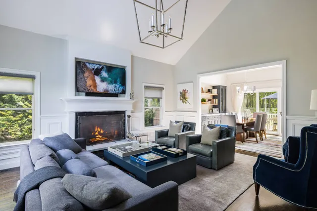 a living room with furniture fireplace and a large window