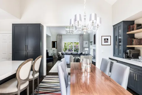 a living room with furniture a chandelier and wooden floor