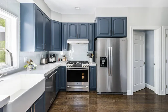 a kitchen with stainless steel appliances granite countertop a refrigerator stove and wooden cabinets