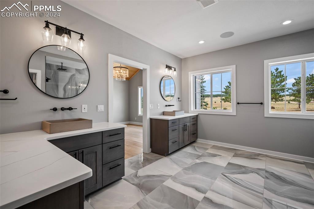 18775 Sweet Road Peyton, CO 80831 - Photo 18 of 50 a spacious bathroom with a double vanity sink and a mirror