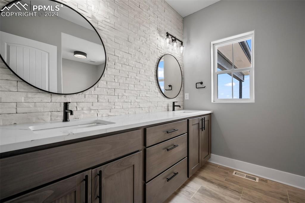 18775 Sweet Road Peyton, CO 80831 - Photo 23 of 50 a bathroom with a double vanity sink and a mirror