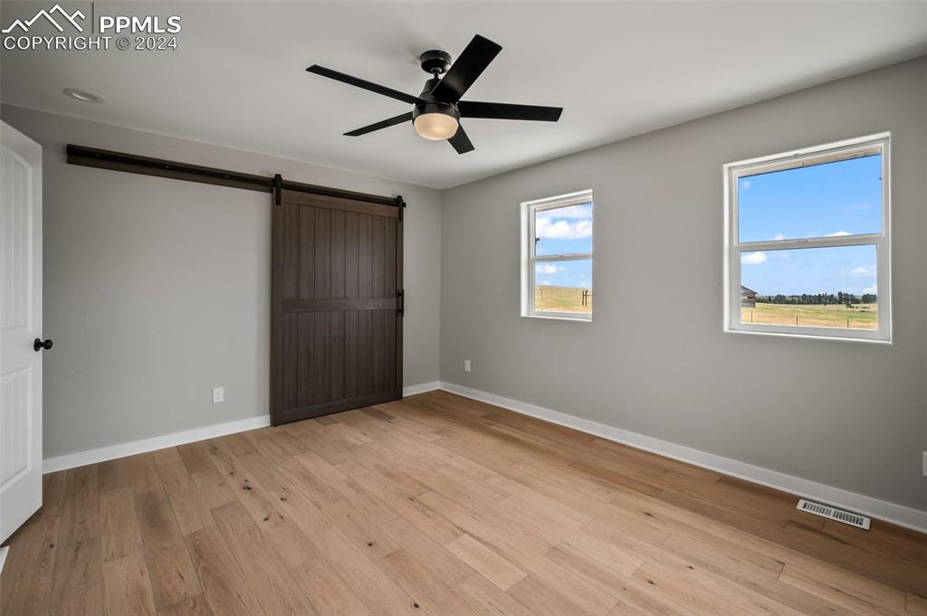 18775 Sweet Road Peyton, CO 80831 - Photo 24 of 50 a view of a big room with wooden floor and windows