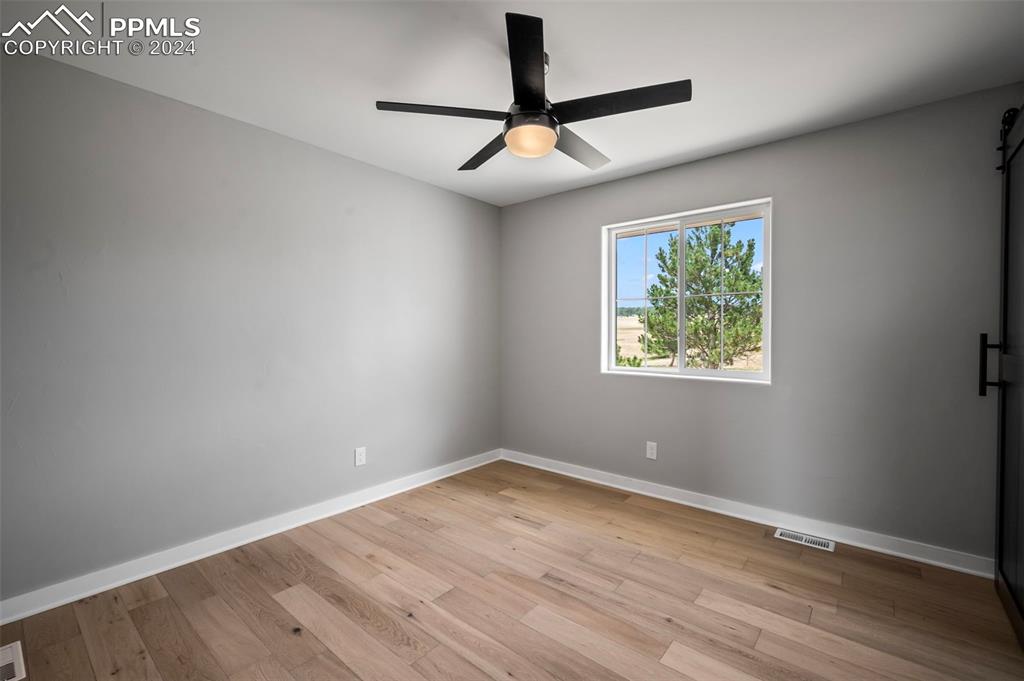 18775 Sweet Road Peyton, CO 80831 - Photo 26 of 50 an empty room with wooden floor and windows
