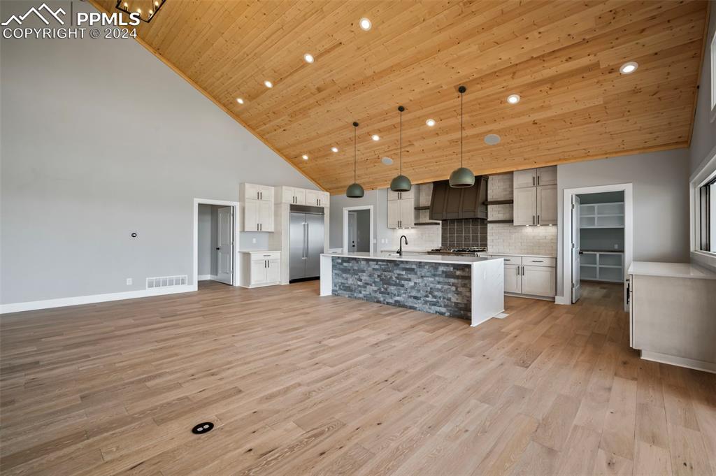 18775 Sweet Road Peyton, CO 80831 - Photo 8 of 50 a large kitchen with stainless steel appliances kitchen island wooden floors and white cabinets